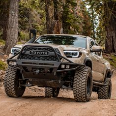 the toyota truck is driving on a dirt road