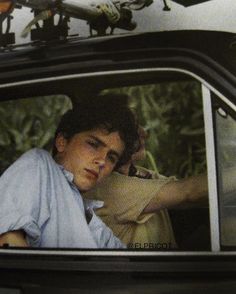 a young man sitting in the passenger seat of a car