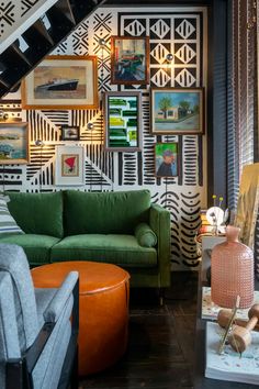 a living room filled with furniture and pictures on the wall next to a stair case