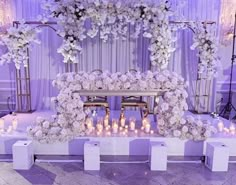 a wedding ceremony setup with white flowers and candles