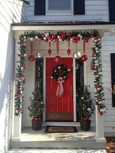 a red front door decorated with christmas decorations