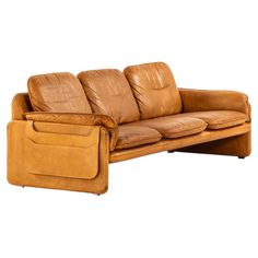 a brown leather couch sitting on top of a wooden table