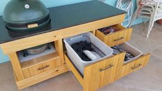 an open drawer in the middle of a kitchen counter next to a large green egg