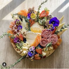 an arrangement of fruits and vegetables arranged in a circle on a wooden table with sunlight coming through the window