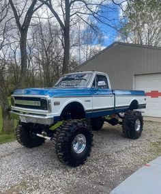 a blue and white truck parked in front of a garage