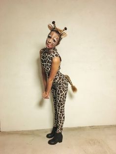 a woman in giraffe costume standing next to a wall