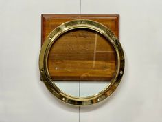 a brass porthole mounted to the side of a wall