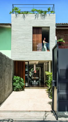 an open door leading to a house with plants growing on the roof and side walls