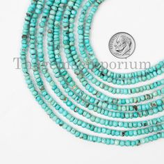 four strands of turquoise beads with silver clasps on each strand and a coin in the background