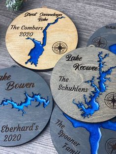 four personalized wooden coasters with the names of three different lakes and rivers on them