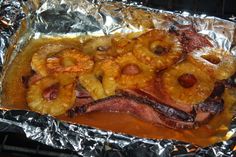 a hot dog covered in bacon and pineapple toppings on foil lined baking sheet