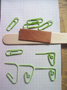 some green paper clips on top of a piece of paper