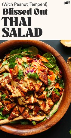 a wooden bowl filled with salad on top of a table