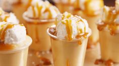 small desserts with caramel sauce and whipped cream on them are arranged in rows