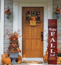 pumpkins and gourds are sitting on the front steps of a house with a happy fall sign