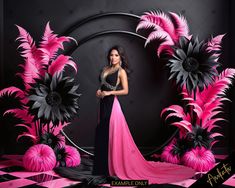 a woman standing in front of a black and pink backdrop with large flowers on it