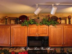 a kitchen with wooden cabinets and black stove top oven under two white lamps above the microwave