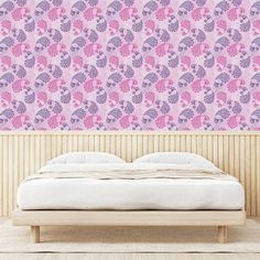 a bed sitting under a pink wall next to a wooden headboard and foot board