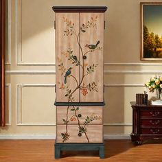 a tall cabinet with birds painted on it in a room next to a table and dresser