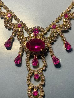 VINTAGE CRYSTAL LAVALIERE Necklace Hot Cerise Pink On Gold Waterfall Statement Sparkling Glamour Evening Party 1950s 1960s Hollywood Couture Featuring a very glamorous necklace filled with vibrant cerise pink and light pink crystals set in a gold metal. This necklace speaks for itself, great to wear with a black evening dress..Dress to impress with this necklace for sure! Unsigned. Measurements: adjustable from 36cm /40cm centre piece from top to bottom 9.5cm long Condition: In ABOVE excellent v Pink Rhinestone Jeweled Costume Necklace, Luxury Pink Necklace As A Statement Piece, Pink Crystal Glamorous Necklace, Glamorous Pink Rhinestone Necklace, Glamorous Pink Crystal-embellished Jewelry, Cerise Pink, Black Evening Dresses, Centre Pieces, Evening Party