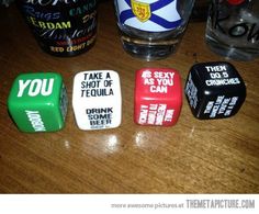 four dices that are sitting on a table next to a glass with alcohol in it