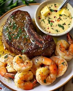 a steak and shrimp with sauce on a plate