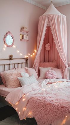 a bed with pink sheets and lights on the headboard is in a girls'bedroom