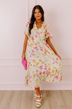 - Drape yourself in petals and twirl in the sun with this airy dress! - Chiffon material with a colorful abstract floral print - A built-in lining that ends above the ruffled hemline - A ruffled v-cut neckline with a tie detail - Short, loose ruffled sleeves - Pleated detail at the bodice - An elastic waistline - A flowy yet flattering silhouette that ends in a ruffled maxi length hemline Cream Dress With Ruffle Hem For Vacation, White Floral Ruffled Dress For Beach, White Bohemian Floral Dress With Ruffles, White Floral Dress With Ruffles For Beach, Feminine Off White Floral Print Dresses, Breezy Floral Print Midi Dress For Garden Party, Flowy Ruffled Floral Dress For Beach, White Bohemian Floral Print Dress, White Chiffon Floral Dress For Spring