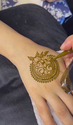 a henna tattoo is being applied on someone's arm