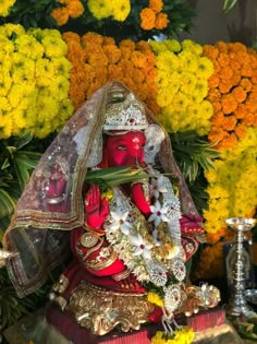 the statue is surrounded by yellow and orange flowers