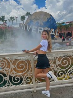 a beautiful young woman standing next to a railing