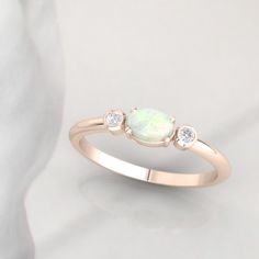 Timeless diamond and opal ring by jewelry designer Ascheron. Excellent handcrafted dainty diamond ring. Beautiful mix of brilliant cut round diamonds and smooth pear cut opal gemstone. Diamonds - 2 diamonds. Total carat weight of 0.08ct. Excellent GVS quality white diamonds. Ethically sourced. Gemstone - Real Opal, oval shape measuring 6 x 4 mm. Band - Measures 1.8 mm wide and 1.6 mm deep. Metals - Available in 14K / 18K, white, yellow or rose gold. Also in Platinum. Shipping - Free shipping to Opal Gemstone Diamond Ring For Anniversary, Anniversary Opal Three Stone Rings, Oval Three Stone Opal Promise Ring, Elegant Three Stone Opal Promise Ring, Opal Ring With Rose Cut Diamonds For Anniversary, Anniversary Opal Ring With Rose Cut Diamonds, Dainty Diamond Opal Ring For Anniversary, Opal Three-stone Ring For Anniversary, Elegant Three Stone Opal Wedding Ring