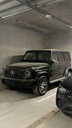 two cars parked in a parking garage next to each other and one is black with chrome wheels