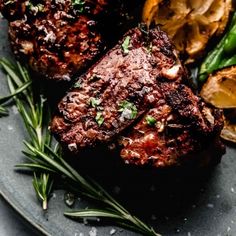 some meat and vegetables on a plate with seasoning sprinkled around it's edges