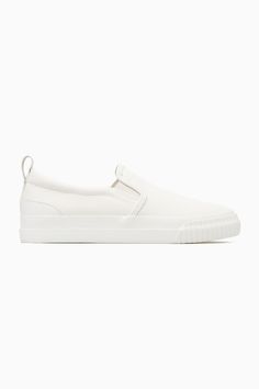 These slip-on trainers are an easy option for summer dressing – they'll go with all your casual outfits but will work equally well to pare back tailoring, too. Crafted from cotton-canvas with leather detailing, they come in versatile white and have chunky rubber soles and elasticated inserts for comfort. The leather pull tab at the back makes them easy to slip on and off. Leather binding and panellingRecycled cotton is made by converting both pre- and post-consumer fabric into fibres that are th White Canvas Slip-ons For Summer, Cotton Slip-ons With Rubber Sole, Slip-on Sneakers With Gum Sole, Canvas Slip-on Sneakers With Gum Sole, Comfortable Slip-on Sneakers With Gum Sole, Modern Slip-on Sneakers With Contrast Sole For Spring, Summer Slip-on Sneakers With Stitched Sole, Low-top Slip-on Sneakers With Rubber Waffle Outsoles, White Casual Platform Sneakers With Stitched Sole