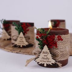 three small candles are decorated with burlocks and twine, one has a christmas tree on it