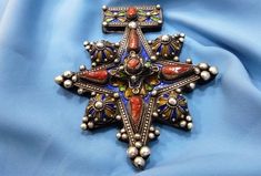 Morocco - Beautiful late 20th century South Moroccan cross called Boghdad in sterling silver, enameled in blue, green and yellow and inlaid with real coral cabochon beads. mainly carried by Sahrawi/Tuareg populations. Fine graining and wonderful silver patina. ✓ Height: 10.5cm. ✓ Width: 9.5 cm. ✓ Leather cord: 54 cm. ✓ Material: sterling silver. ✓ Weight: 76.6 grams. ✓ Origin: South of Morocco 1950s. ✓ Shipping will always be via DHL for free. ✓ Shipping to USA 3-7 business days. ✓ Shipping to E Traditional Cross Pendant Necklace As Gift, Traditional Cross Pendant Necklace For Gift, Traditional Collectible Necklace For Festivals, Heavy Antique Pendant Jewelry, Traditional Necklace With Large Cross Pendant, Antique Heavy Pendant Jewelry, Traditional Cross Pendant Necklace With Large Pendant, Traditional Handmade Cross Necklace, Antique Cross Jewelry With Large Pendant