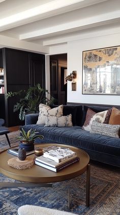 a living room filled with furniture and a large painting on the wall above it's coffee table