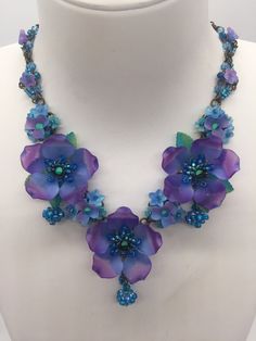 Violet Poppy Necklace Handmade by Vintage Jewelry Designer Colleen Toland Poppy necklace in pretty colors of deep purple and and soft turquoise make this necklace a stand out. There are 3 large poppy flowers along with clusters of smaller flowers and pretty blue beaded bawl bawl drops. The necklace part is constructed with tiny purple flowers in a diamond pattern, that is original to Colleen Toland and a signature design element on many of her pieces. Matching earrings are listed below. This is Poppy Necklace, Soft Turquoise, Poppy Flowers, Vintage Inspired Jewelry, Acrylic Flowers, Clay Flowers, Cactus Flower, Colourful Necklace, Jewelry Designer