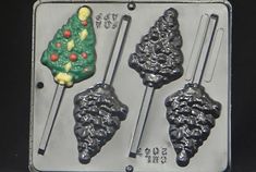 three cookie molds in the shape of christmas trees