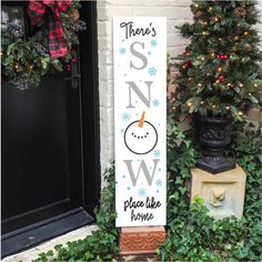 there's snow place like home sign next to a christmas tree and potted plant