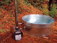 a large metal tub sitting on top of a brick walkway