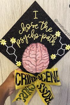 someone is holding up a graduation cap with a brain on it