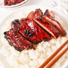 meat and rice on a plate with chopsticks