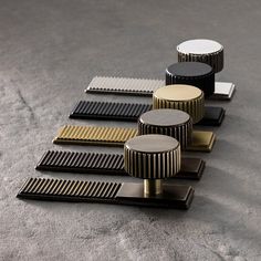 several different types of combs sitting on the ground next to each other, all in gold and black