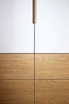 a close up of a wooden door with white walls in the background and wood flooring