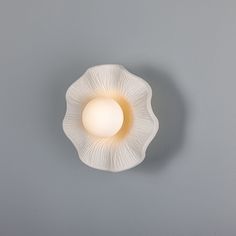 a light that is on the side of a wall in front of a gray background