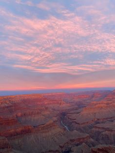 the sun is setting at the edge of the grand canyon, with water running through it