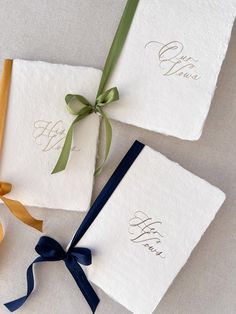 three personalized wedding guest towels tied together with a blue ribbon and gold lettering on them