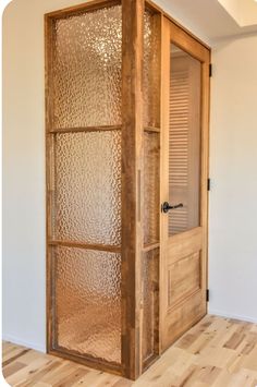 an empty room with a glass door and wooden floor